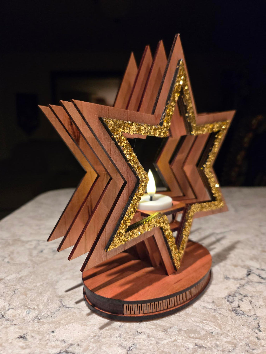 Pair of star candle holders with glowing tealights on wooden surface