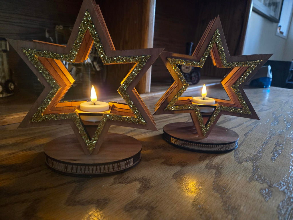 Two star candle holders on wooden table with warm candlelight