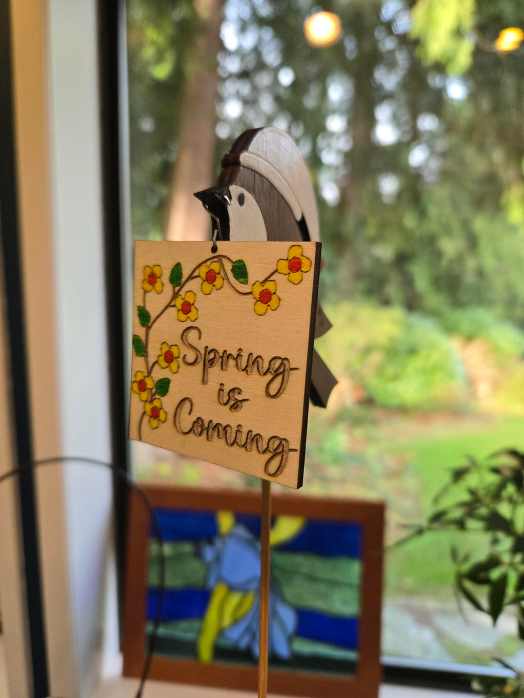 Multiple Spring is Coming garden stakes displayed together in sunny window setting