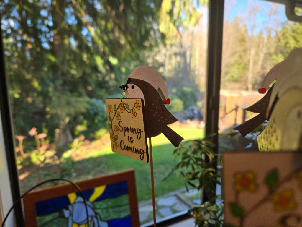 Multiple Spring is Coming chickadee garden stakes displayed in plant pots